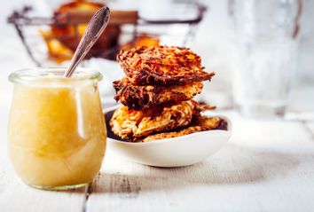 Jar of apple sauce and bowl of crispy potato latkes