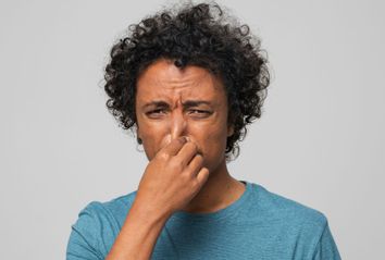 Young man holding nose