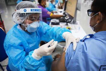 A health worker prepares to administers a dose of the COVID-19 vaccine