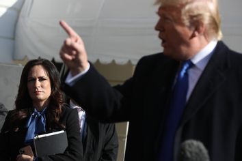 White House Press Secretary Stephanie Grisham (L) listens to U.S. President Donald Trump talk to reporters before he boards Marine One and departing the White House November 08, 2019