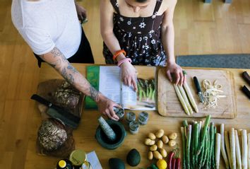 Overhead view of couple reading a cooking recipe