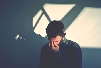 Upset Man Standing Against Wall