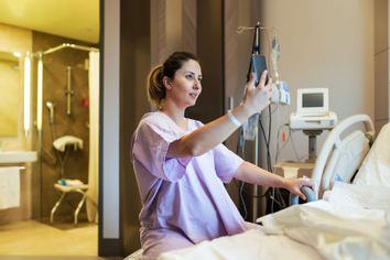 Young pregnant woman in the hospital ward having video call