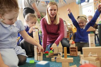 Teacher playing with children at school