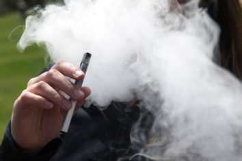 A person smokes a Juul e-cigarette