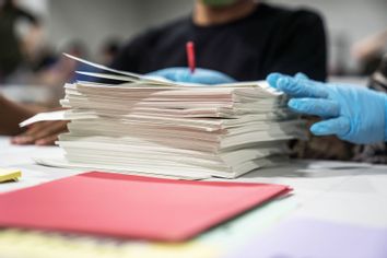 election workers handle ballots