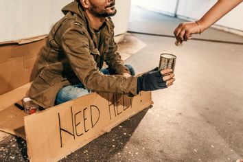 Photo of a person giving money to a beggar