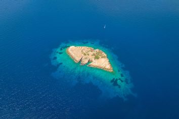 A boat approaching a small island in the Aegean Sea