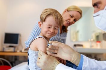  Little boy feeling pain while getting a vaccine