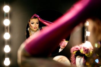 Drag queen admiring herself in the mirror in a dressing room