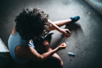 Young caucasian female addict preparing heroin dose.