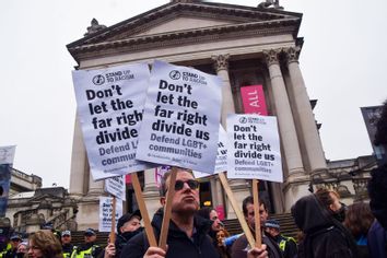 A pro-LGBTQ rights protester holds anti-far-right placards during the demonstration.