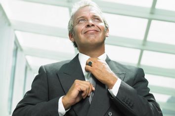 Mature businessman adjusting tie