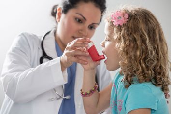 Doctor helping patient use inhaler