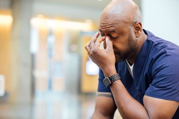 Tired man pinching brow