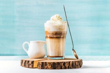 Coffee with whipped cream, spoon and milk pitcher