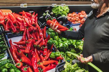 Older man inspecting peppers