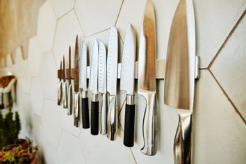 Close up shot of kitchen knives on wall in kitchen