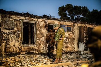 Israeli soldier inspects a destroyed house