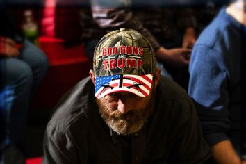 A supporter of Donald Trump wears a hat displaying a logo that is pro-guns and Trump