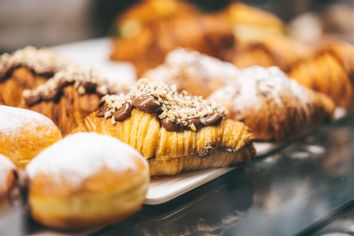 Homemade flaky pastry dough croissants, moist donuts, and buns with various flavored fillings
