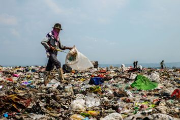 A scavenger looks for plastic bottles at Jabon landfill on April 22, 2021 in Sidoarjo, East Java, Indonesia.
