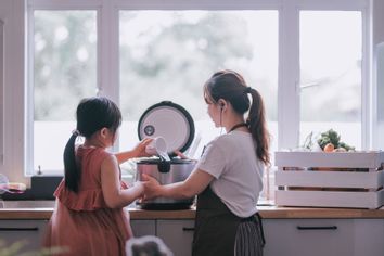 Mom and daughter using rice cooker