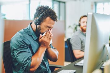 Sick sneezing office worker