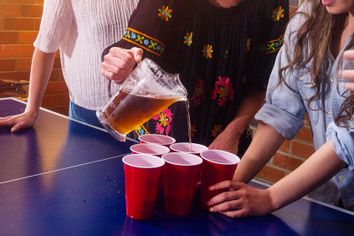 Woman holding pitcher with beer and pouring drinking at a party