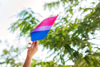 Woman holding a bisexual pride flag