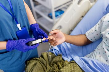 Nurse taking blood to check sugar levels of a patient