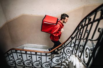 Delivery guy walking up stairs building