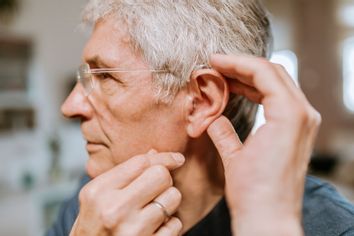 Senior man with hearing aid ear close up