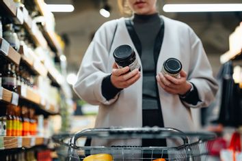 Woman comparing products in supermarket grocery store