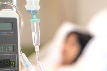 Child patient with IV line in hospital bed