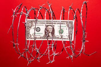 US dollar bill inside coil of steel barbed wire