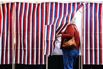 A person enters a voting booth