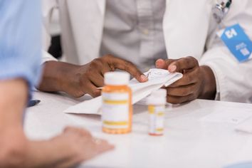 Pharmacist discussing medication at pharmacy counter