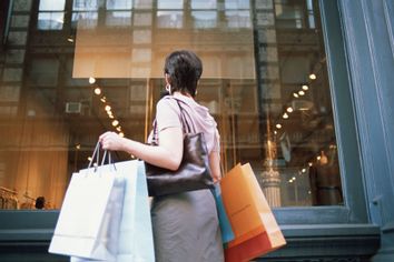 woman shopping spree bags storefront window