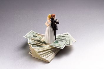 Wedding figurine couple back to back on a pile of US dollars