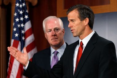 U.S. Senator John Thune discusses his opposition to the passage of the $858 billion tax-cut bill as Senator John Cornyn looks on during a news conference on Capitol Hill in Washington