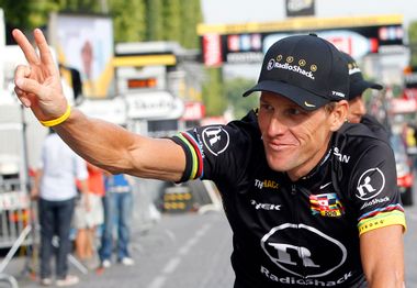 Radioshack team rider Lance Armstrong of the U.S. waves on the Champs Elysees in Paris during the final parade of the 97th Tour de France cycling race