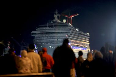 The Carnival Triumph cruise ship is towed towards dock at the port of Mobile