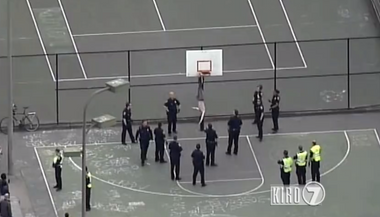 Image for How many Seattle police officers does it take to rescue a shirtless protestor from a basketball hoop?