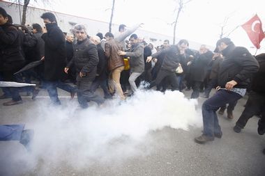 Riot police use tear gas to disperse protesting employees and supporters of Zaman newspaper at the courtyard of the newspaper's office in Istanbul
