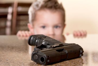 Gun on table in front of child
