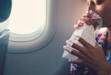 Woman breathing in bag on plane