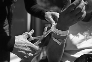 A nurse from Joseph's House removes ID bracelets