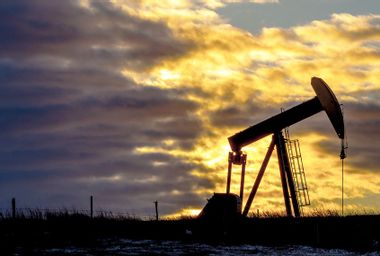 Pumpjack at oil industry against cloudy sky during sunset in North Dakota, USA
