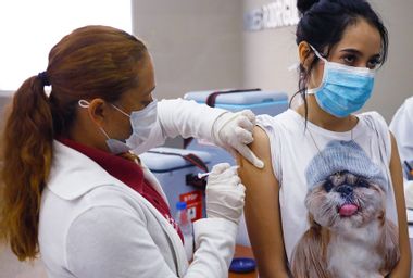 A nurse applies a vaccine to her patient